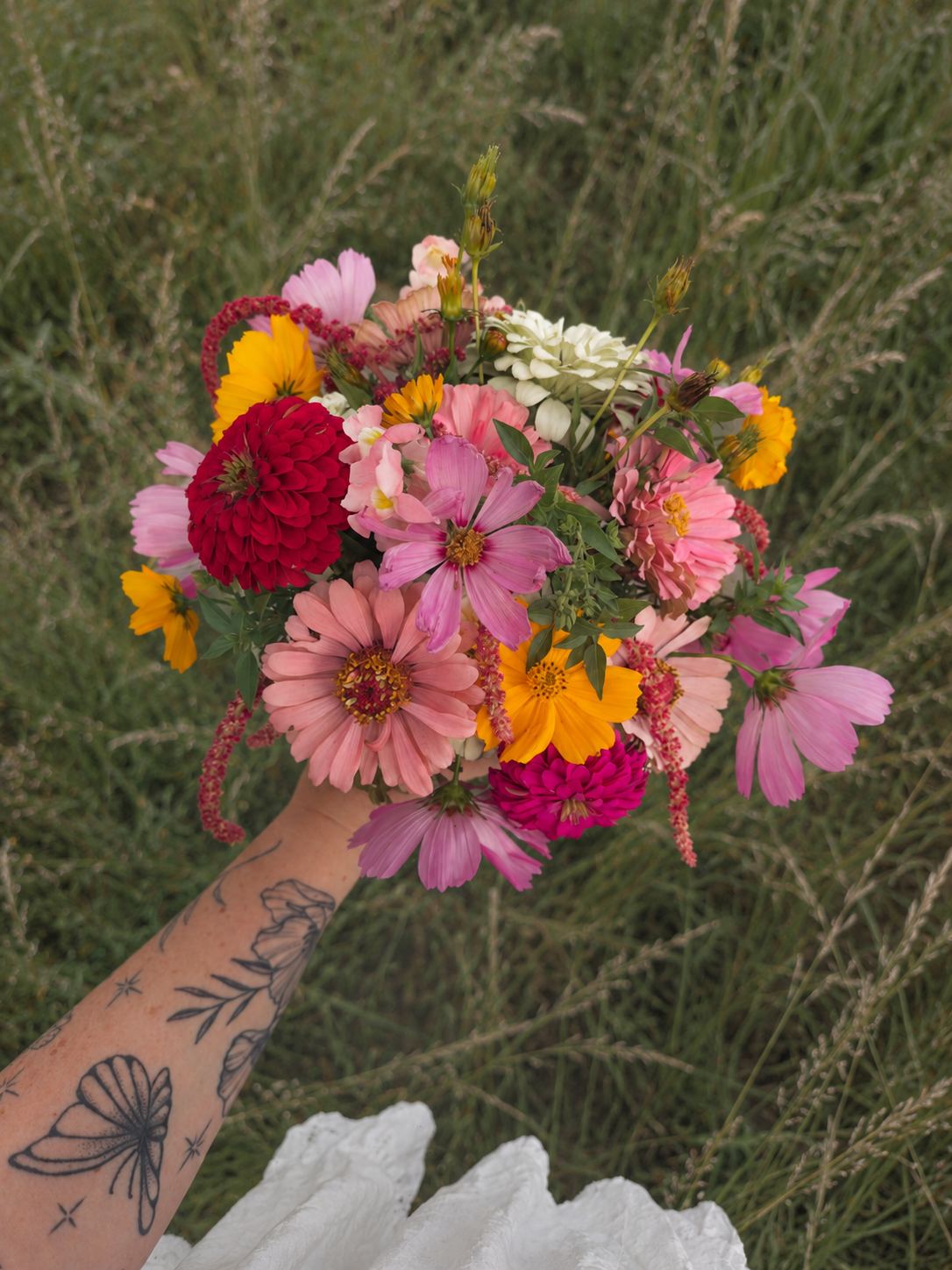 A bouquet of cosmos, zinnias and deep red dahlias in pink and coral