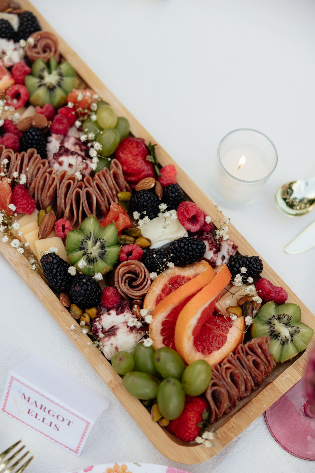 A grazing board of papaya, grapes, blackberries and chocolate-dipped strawberries by candlelight