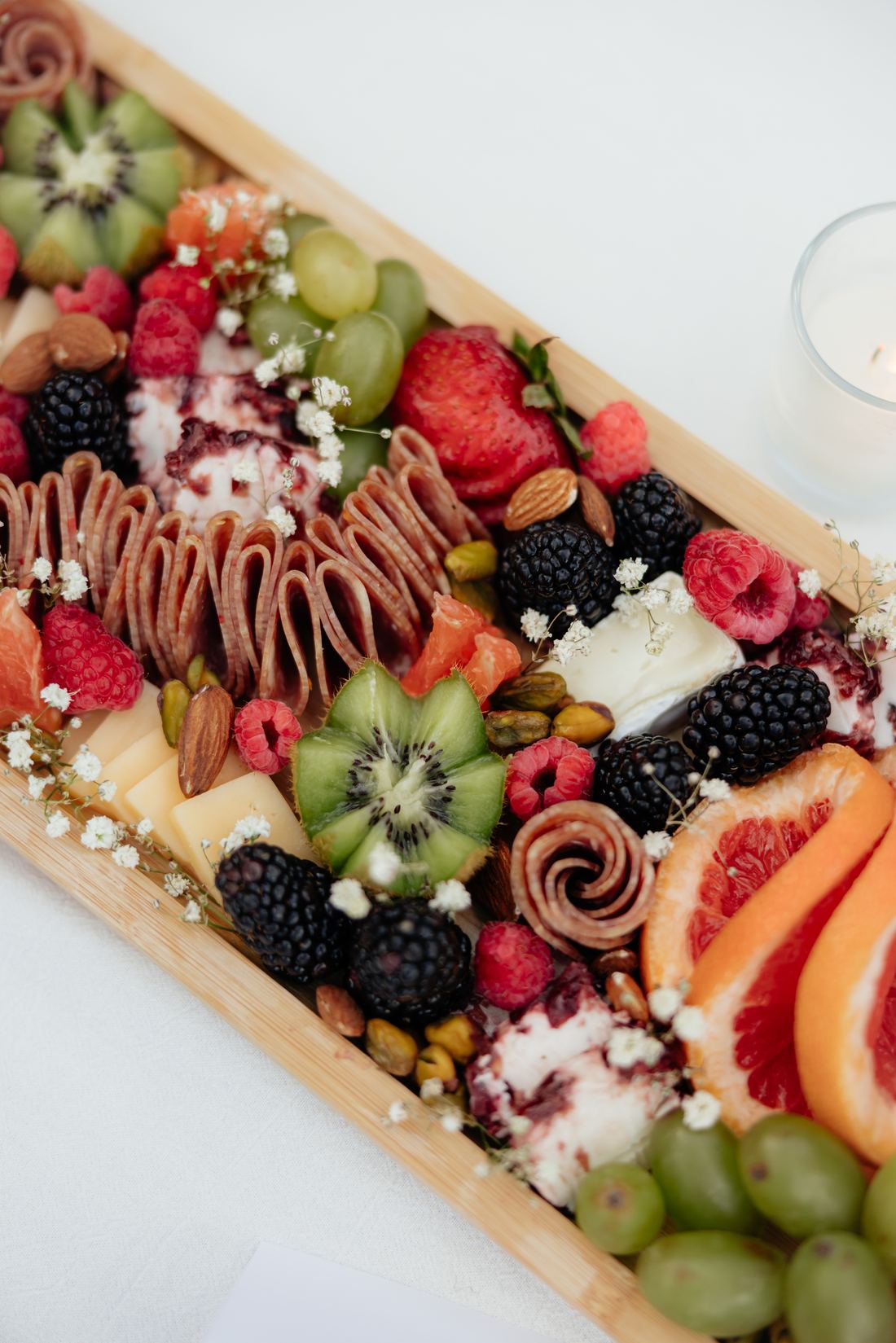 A grazing board close up with strawberries, grapes, blackberries and dipped fruit
